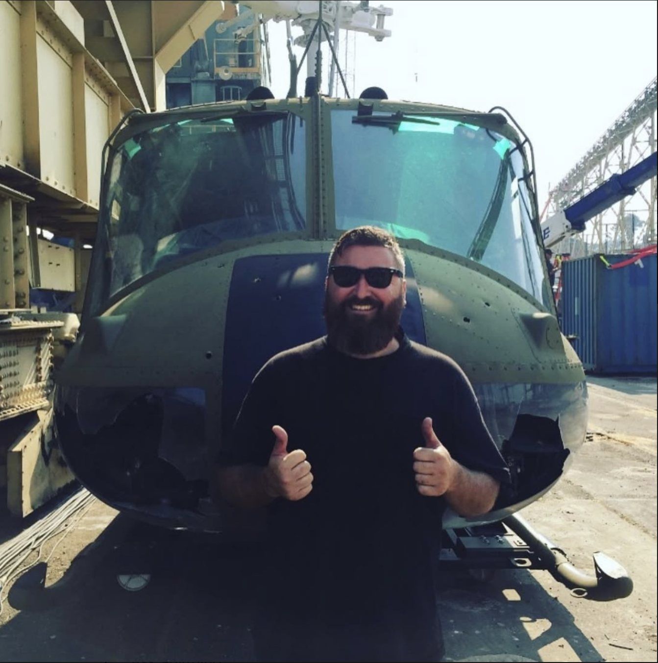 Daniel giving two thumbs up in front of a helicopter on location for Transformers: Bumblebee in San Francisco